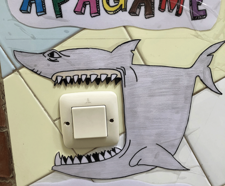 Dibujo de un tiburón con la boca abierta sobre un interruptor y dice "Apágame"